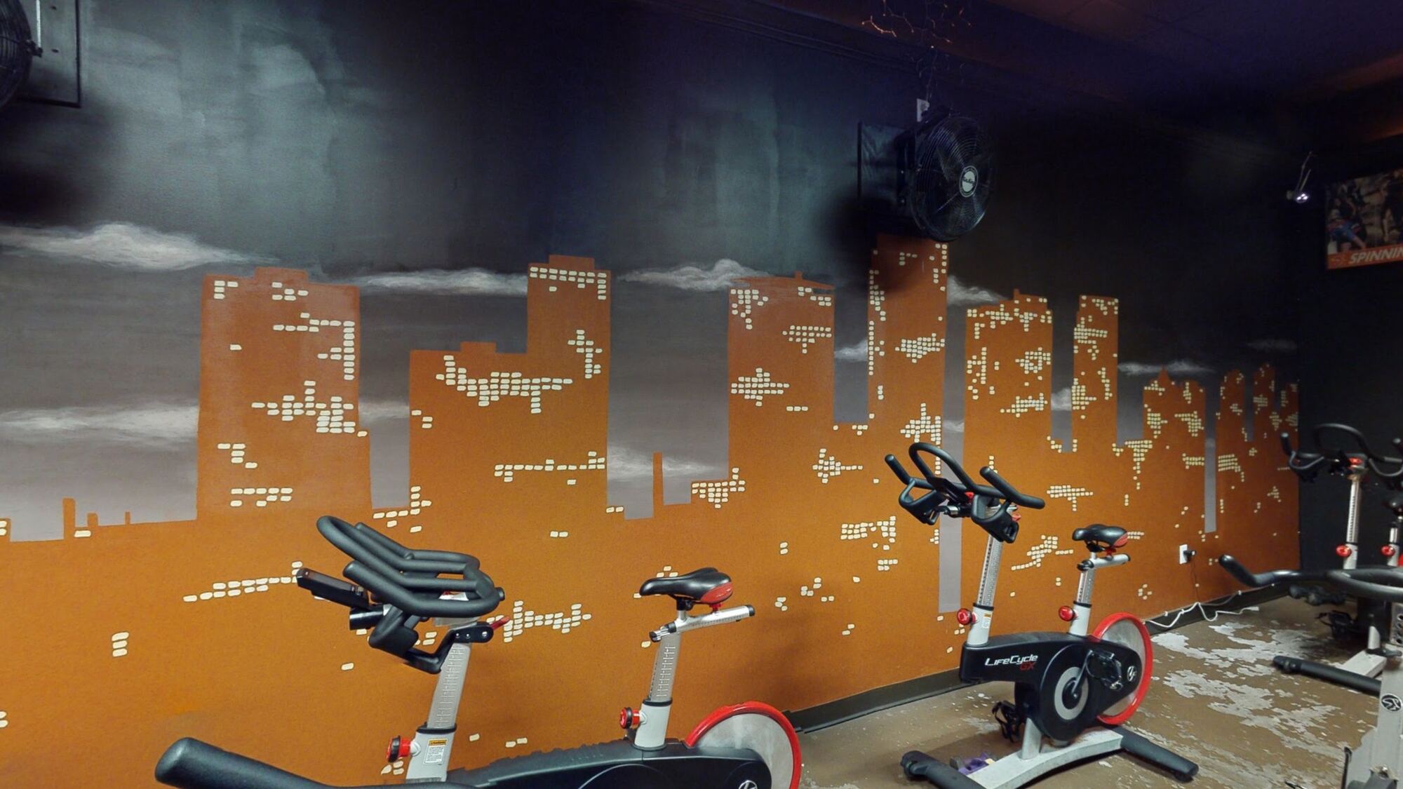 Indoor cycling studio with skyline mural